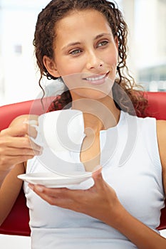 Portrait of young woman relaxing with cup of tea