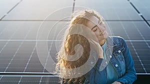 Portrait of young woman on roof with solar panels.