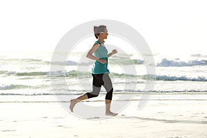 Portrait of young woman running along the beach