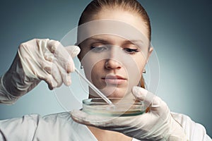 Portrait of young woman - scientist with dropper working