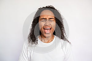 Portrait of young woman screaming with closed eyes