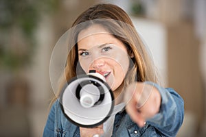 portrait young woman screaming on megaphone