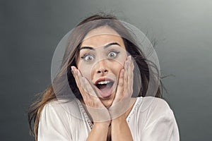 Portrait of young woman with shocked facial expression