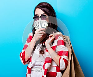 Portrait of the young woman with shopping bags and money