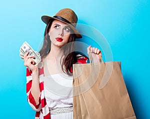 Portrait of the young woman with shopping bags and money