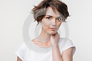 Portrait of young woman with short brown hair in basic t-shirt looking at camera