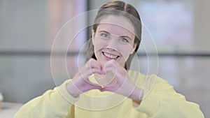 Portrait of Young Woman showing Heart Shape by Hands