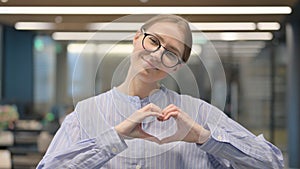 Portrait of Young Woman showing Heart Shape by Hands