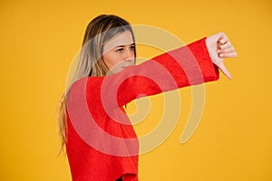 Portrait of a young woman showing a thumb down.