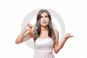 Portrait of a young woman showing thumbs down gesture over white background