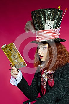 Portrait of young woman in the similitude of the Hatter reading