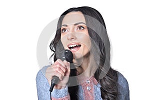 Portrait of young woman singing with microphone on white background