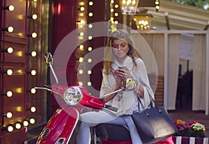 Portrait of young woman sitting on the scooter