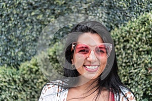 Portrait of a young woman with a smile and sunglasses in the city