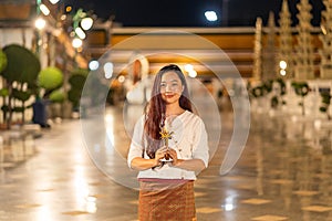portrait young woman is smiling holding candle at Wat Suthat Thepwararam in night