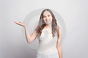 Portrait of young woman smiling and holding product on palm