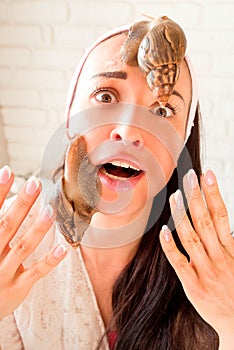 Portrait of young woman with snails on her face