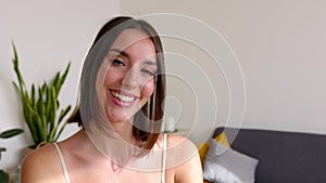 Portrait of young woman in sportswear smiling at camera standing at home