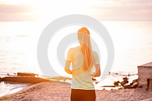 Portrait of young woman in sportswear, stopped for break between workouts. Sportswoman looks at dawn