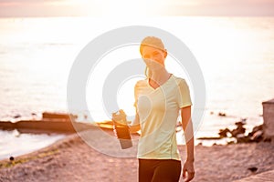 Portrait of young woman in sportswear, stopped for break between workouts. Sportswoman looks at dawn