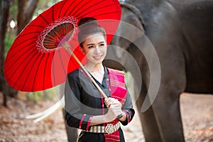 Portrait Of Young Woman Standing By Elephant In Forest