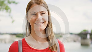 Portrait of young woman standing on waterfront in Paris. Young lonely tourist travelling in Europe