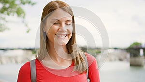 Portrait of young woman standing on waterfront in Paris. Young lonely tourist travelling in Europe