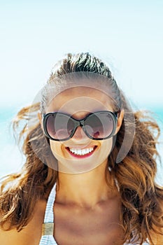 Portrait of young woman in sunglasses on beach