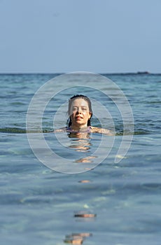 Portrait of young woman swimming in the ocean