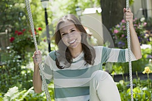 Portrait of a young woman on a swing