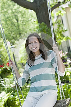 Portrait of a young woman on a swing