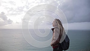 Portrait of young woman teenager traveler in glass on coast of normand.