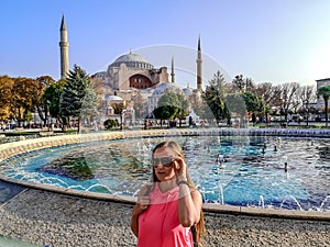 Portrait of a young woman tourist in sunglasses on the background of Hagia Sophia in Istanbul Turkey. Adult long-haired blonde