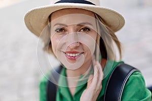 Portrait of young woman traveler, sitting, resting, smiling and looking at camera.