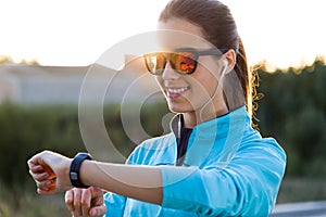Portrait of young woman using they smartwatch after running.