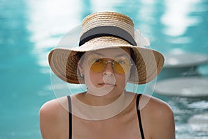 Portrait of a young woman on vacation. Girl in a straw hat and sunglasses.