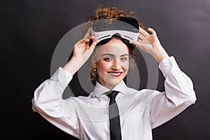 Portrait of a young woman with virtual reality goggles in a studio.
