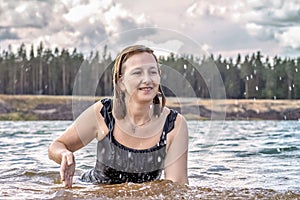 Portrait of a young woman in the water. Swimming in the lake,splashes