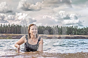 Portrait of a young woman in the water. Swimming in the lake,splashes