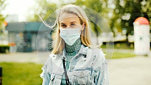 Portrait of young woman wearing antibacterial mask in a city.