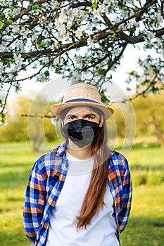 Portrait of young woman wearing black face mask. Dust protection against virus. Coronavirus pandemic time. Girl in American