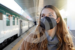 Portrait of young woman wearing a black protective mask KN95 FFP2 on train station