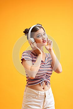 Portrait of a young woman wearing headphones listening to music