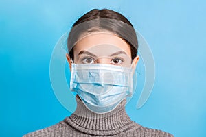 Portrait of young woman wearing medical mask at blue background. Protect your health. concept