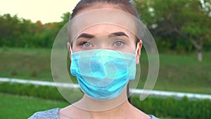 Portrait of a young woman wearing protective mask on street