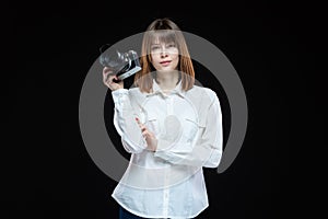Portrait of a young woman wearing a white shirt holding a camera in her hand. The concept of a successful photographer