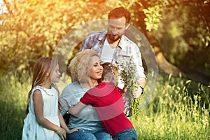 Portrait of young woman in wheelchair hugging her family