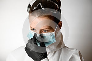 Portrait of young woman which regulate medical mask on her face