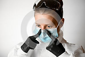 Portrait of young woman which regulate medical mask with her fingers