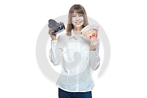 Portrait of a young woman in a white shirt holding a camera and Russian money rubles in her hand. The concept of a